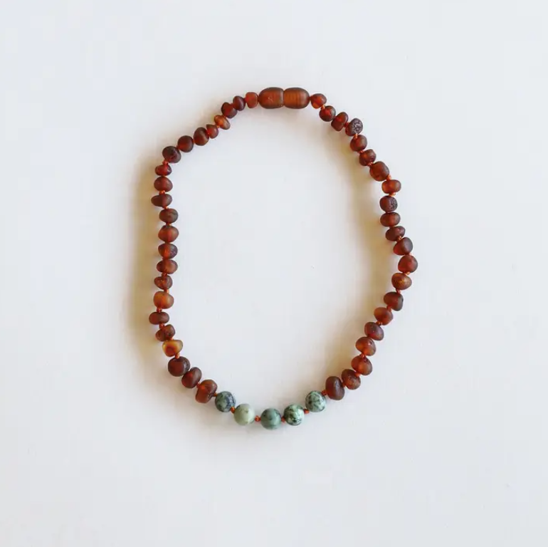 This Raw Cognac Baltic Amber + Turquoise Jasper Beaded Necklace by CanyonLeaf is handmade using original Baltic Sea Amber that is over 45 million years old. Baltic Amber has some of the highest concentrations of Succinic Acid found in nature and this is what makes it so special. Fossilized tree sap that has been preserved for millions of years under the sea. It is a true gift from Mother Nature.&nbsp;