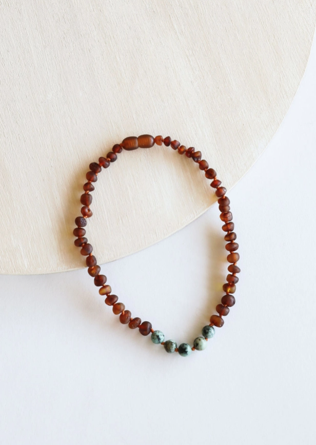 This Raw Cognac Baltic Amber + Turquoise Jasper Beaded Necklace by CanyonLeaf is handmade using original Baltic Sea Amber that is over 45 million years old. Baltic Amber has some of the highest concentrations of Succinic Acid found in nature and this is what makes it so special. Fossilized tree sap that has been preserved for millions of years under the sea. It is a true gift from Mother Nature.&nbsp;